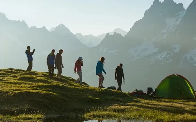 Friends walking near a mountain campsite